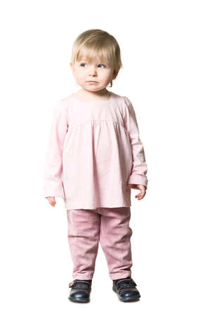 One little child standing on floor. Pink clothes. Isolated on white backgroundの写真素材