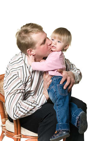Father and little child are sitting on sofa and holding hands. Isolated on white background. Studio shotの写真素材