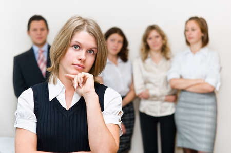 Five business persons a team standing in a row on background. On a foreground one beautiful womenの写真素材