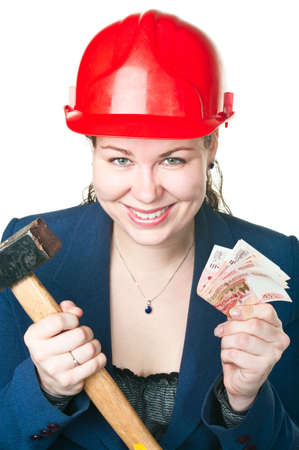 The girl in a building helmet with a hammer and cash in hands. It is isolated on a white backgroundの写真素材