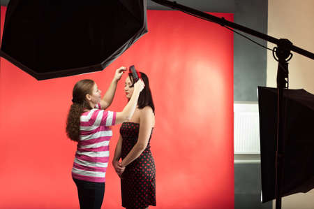 Stylist make image of contemporary model in photographic studio. Two young women. Photo equipmentの写真素材