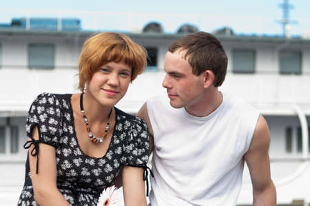 Young loving couple teens sitting. Two Caucasian people. Teenagers: girl and boy embracing one anotherの写真素材