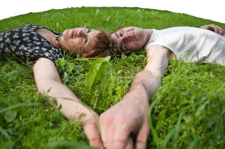 Young loving couple teenagers sitting on green grass. Two Caucasian peopleの写真素材