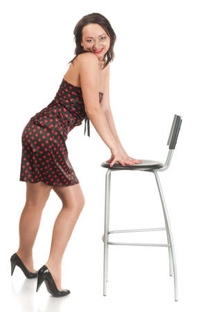 Beautiful white woman in dress on armchair. Long hair. Studio shot. White background, isolatedの写真素材