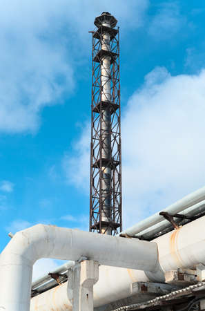Industrial steel chimney in factory on blue sky