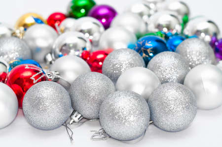 Four grey Christmas balls on foreground and many color balls on backgroundの写真素材