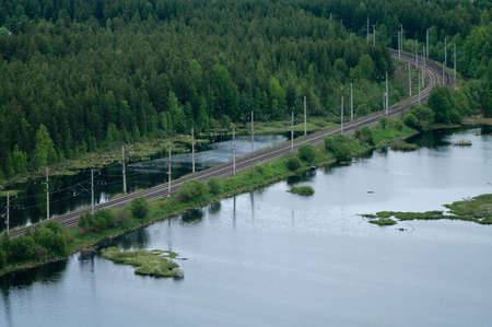 Railroad between forests and lakes. Top view. Air viewの写真素材