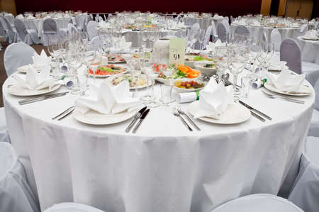 Wedding white reception place ready for guests. Elegant banquet tables prepared for a conference or...