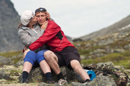 Young woman kissing a man in mountainsの写真素材