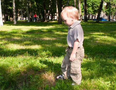 Little boy walking in park in sunny dayの写真素材