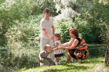 Family a four people walking in summer park in sunny dayの写真素材