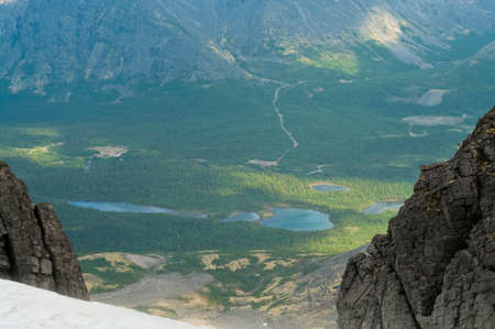 View on green valley from peak of big mountain in Khibin massive, Russiaの写真素材
