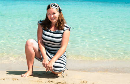 Young pretty girl on a sandy beach near the shore blue seaの写真素材