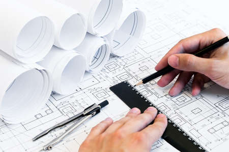 Design drawings and human hands drawing a project by pencil on paperの写真素材