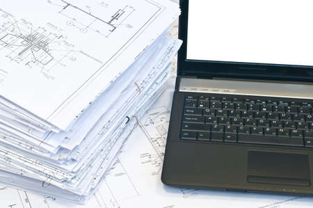 Laptop and stack of project drawings. Working place. White screenの写真素材