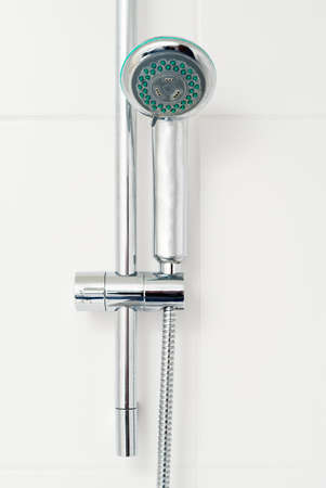 Bath shower on white tile wall
