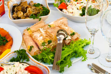 Plates with cold snack on table, cutlery for dinner, white napkin, selective focus.の写真素材
