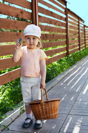 Little child standing with basket in summer timeの写真素材