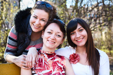 Portrait of three happy friends with a women smiling. Looking at camera. の写真素材