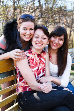 Portrait of three happy friends with a women smiling. Looking at camera. の写真素材