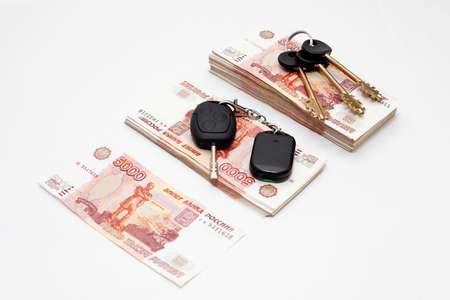 House and car keys on stack of Russian money on white backgroundの写真素材