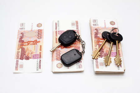 House and car keys on stack of Russian money on white backgroundの写真素材