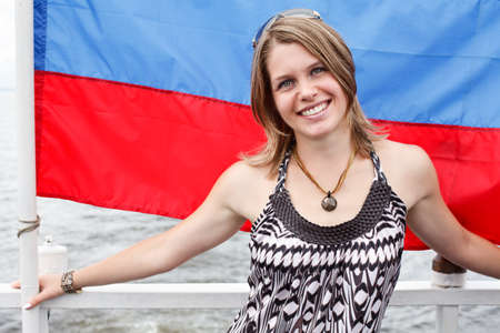 One Russian beautiful young woman is standing under flag of Russiaの写真素材