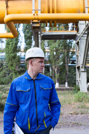 Young handsome man constructor in white hardhat and blue uniform.の写真素材