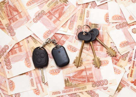 House keys and car key on money cashnotes backgroundの写真素材