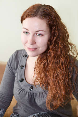 Young woman portrait with curly brown hair. Smiling one person