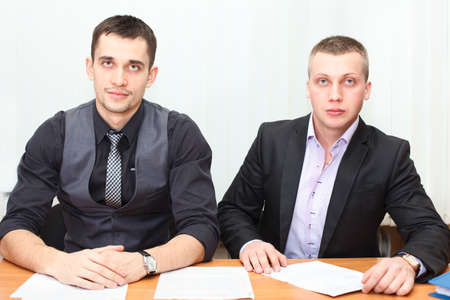 Smiling business men working together at officeの写真素材