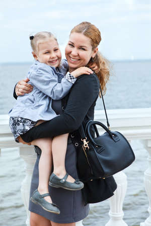 Happy mother and daughter on woman hands  Standing on seacoastの写真素材