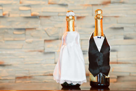 Two bottles of champagne in bride and groom clothes in table  Copy spaceの写真素材