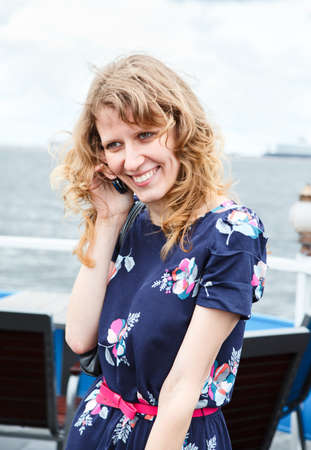 Beautiful Caucasian woman in dress calling with mobile phone.の写真素材