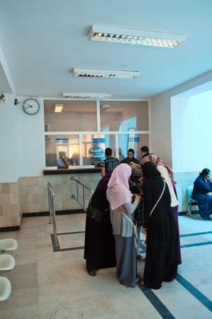 SOUSSE, TUNISIA - CIRCA MAY, 2012: Women in national clothes standing near ticket office and buying...
