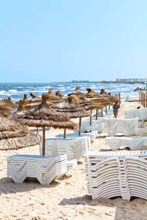 MONASTIR, TUNISIA - CIRCA MAY, 2012: Cleaning a territory with white plastic sunbeds and palm...