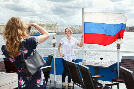 Woman photographing with Russian flag on ship deckの写真素材
