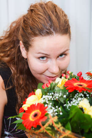Happy smiling young woman with flowers bunch close up portraitの写真素材