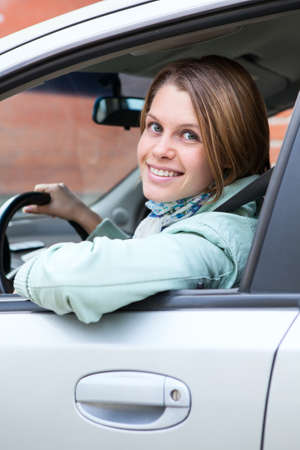 Blond hair woman driver looking back from car window