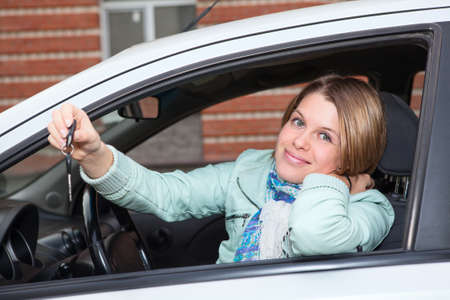 Ignition key in hand of female sitting in carの写真素材