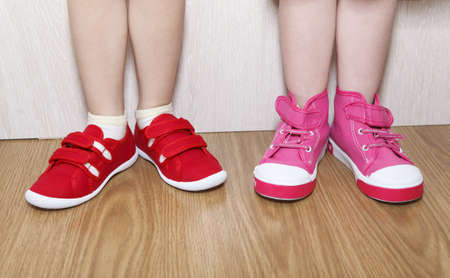 Children in wrong feet and right feet shoes wearing on legsの写真素材