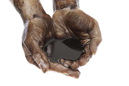 Caucasian hands cupped with black heavy fuel isolated on white backgroundの写真素材