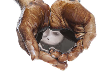 Caucasian two hands cupped with black petroleum isolated on white backgroundの写真素材