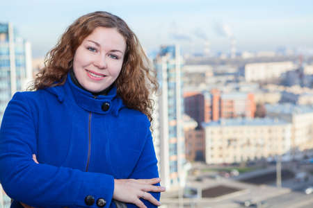 Woman with curly hair standing with city from birdの写真素材