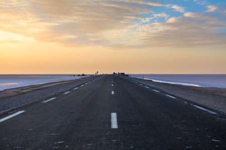 Sunset in solt lake in early morning in empty road, Tunisiaの写真素材