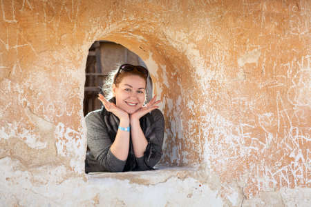 Caucasian woman in ancient wall loophole cheerful and happyの写真素材