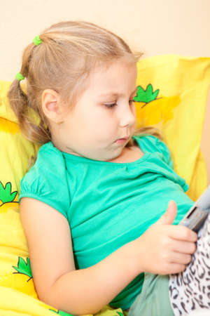 Preschool child with a tablet computer in the handsの写真素材