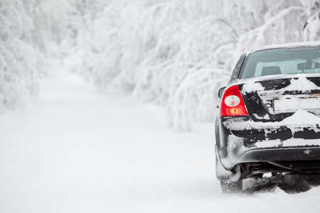 Black land vehicle standing on winter road on roadsideの写真素材