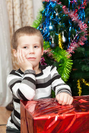 Small boy portrait with gifts near Christmas treeの写真素材