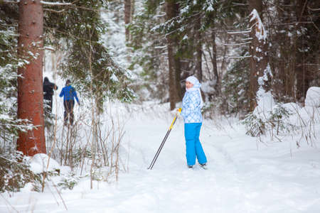 Female skier looking back when skiing in winter forestの写真素材